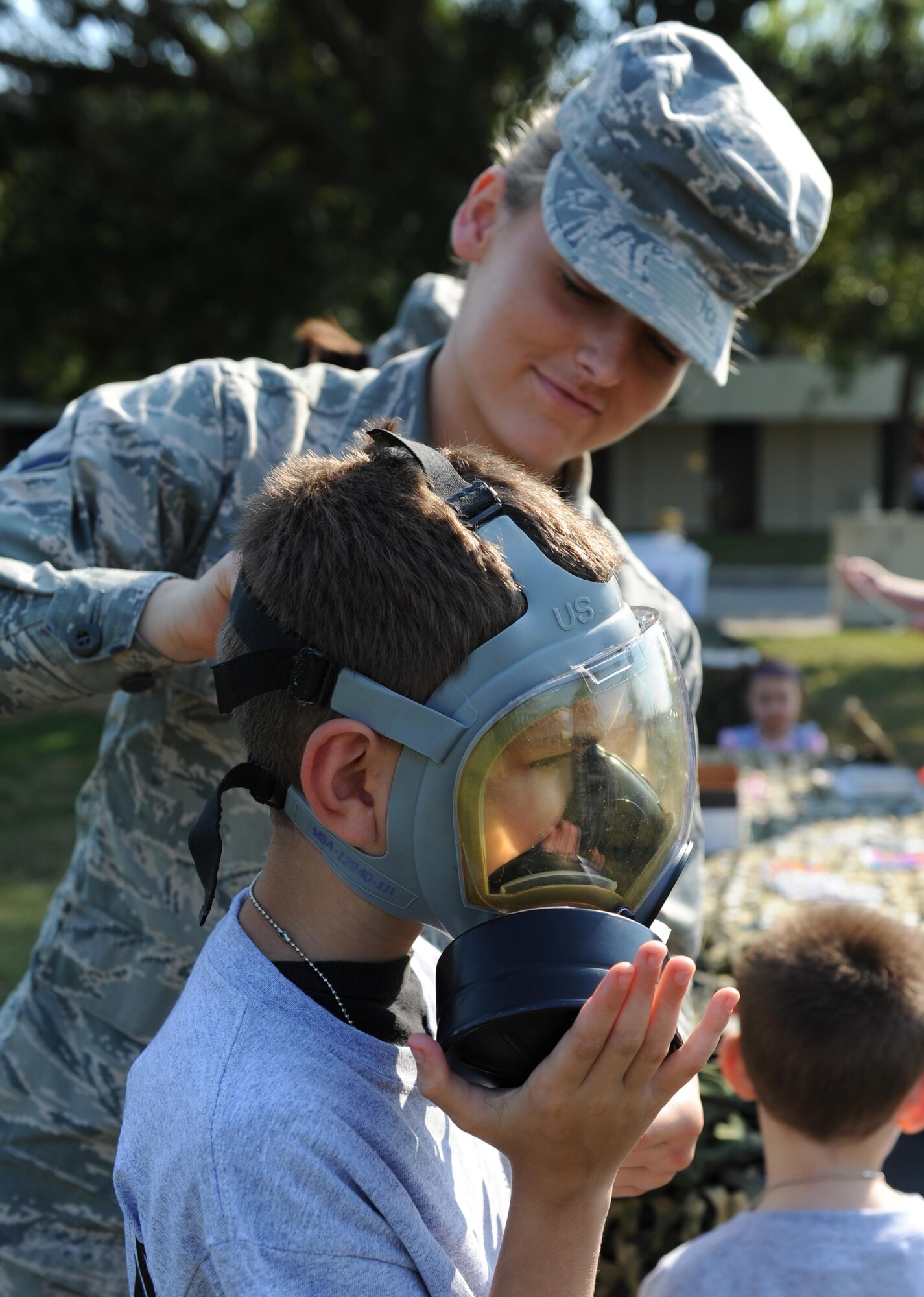 Airman Elizabeth Kuc, 81st Dental Squadron dental technician, secures a gas mask on James Alexander, Jr., son of Staff Sgt. James Alexander, 338th Training Squadron instructor, during Operation Hero Oct. 10, 2015, Keesler Air Force Base, Miss. The event was designed to help children better understand what happens when their parents deploy.  (U.S. Air Force photo by Kemberly Groue)