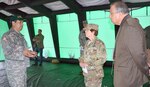 Chief Warrant Officer 3 Val Gonzalez (left), Community Emergency Response Team trainer, talks about the command tent that would be available to all CERT volunteers in the event of a disaster to Maj. Gen. Jimmie Keenan (center), deputy commanding general (operations), U.S. Army Medical Command and chief of the Army Nurse Corps, and Fil Jimenez (right), technical director for installation support, 502nd Air Base Wing and Joint Base San Antonio and other military leaders who attended the CERT kick-off ceremony at MacArthur Parade Field Sept. 11.