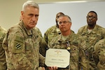 Army Maj. Gen. Mike Murray (left),U.S. Forces Afghanistan deputy commanding general – support, presents the Defense of Freedom Medal to Robert DeLong. 