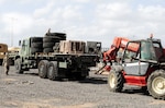 Personnel prepare to unload excess and scrap tires and equipment on Camp Lemonnier, Djibouti, Oct. 16. The camp is undertaking a first-ever massive cleanup effort to reduce excess and scrap material on the base with the support of the Defense Reutilization & Marketing Service.