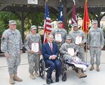 (Standing, from left) Maj. Gen. William L. Smith, Sgt. Michael Cantu, Spc. James Burkett, Staff Sgt. Guadalupe Chapa and Col. Mark Swofford, join Texas Gov. Greg Abbott and Spc. Jose Romo (seated) pose for a photo after the Texas Purple Heart ceremony Sept. 24 at the Warrior and Family Support Center’s Purple Heart Garden on Fort Sam Houston. Smith is the Army assistant adjutant general and commander of the Texas Army National Guard and Swofford is the Brooke Army Medical Center deputy commander for administration.