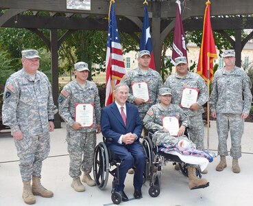 (Standing, from left) Maj. Gen. William L. Smith, Sgt. Michael Cantu, Spc. James Burkett, Staff Sgt. Guadalupe Chapa and Col. Mark Swofford, join Texas Gov. Greg Abbott and Spc. Jose Romo (seated) pose for a photo after the Texas Purple Heart ceremony Sept. 24 at the Warrior and Family Support Center’s Purple Heart Garden on Fort Sam Houston. Smith is the Army assistant adjutant general and commander of the Texas Army National Guard and Swofford is the Brooke Army Medical Center deputy commander for administration.
