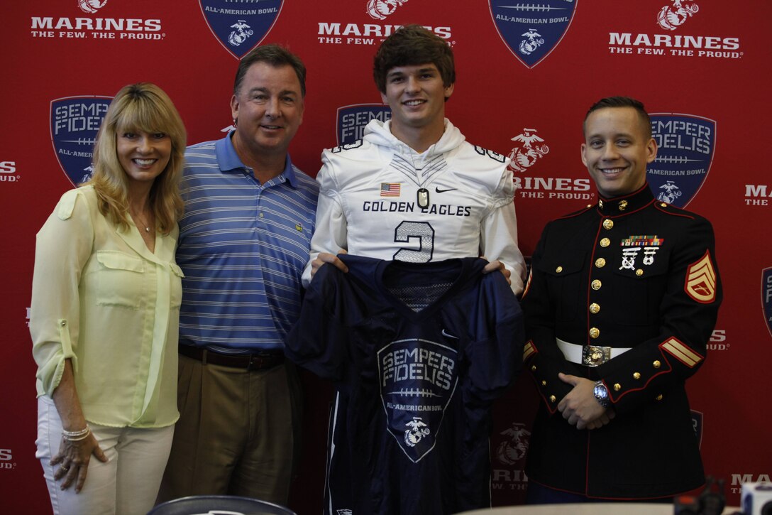 Chris Riley of Naples High School, Naples Florida stands beside his mother and father after receiving his Semper Fidelis All-American Bowl Jersey from SSgt Michael Morin, a Canvassing Marine Recruiter from Recruiting Sub-station Naples. Chris Riley will represent the Eastern Recruiting Region’s team in Carson California live on Fox Sports 1 on January 3rd.(Photo by Sgt Michael Lopez, RS Fort Lauderdale)