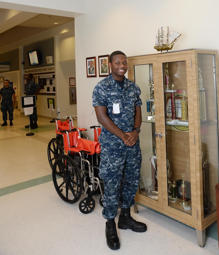 HA Christopher B. Mincey, hospital apprentice, Naval Branch Health Clinic Albany, shares some history and facts as sailors, here, honor the service of the USS Constitution naval ship during a presentation commemorating the Navy’s 240th birthday at Marine Corps Logistics Base Albany, Oct. 13. A replica of the historical USS Constitution is displayed atop a trophy case in the lobby area at NBHC Albany.
