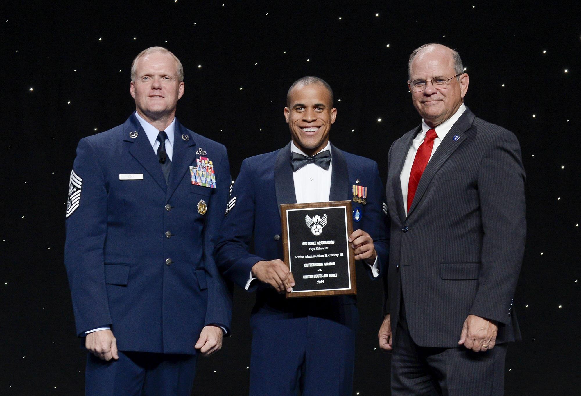 Chief Master Sergeant of the Air Force James Cody and Air Force Association Vice Chairman of the Board Scott Van Cleef flank Senior Airman Allen Cherry at an award ceremony during which Cherry is officially honored as a member of the 12 Outstanding Airmen of the Year, National Harbor, Md, September 14, 2015. (Air Force photo Andy Morataya)