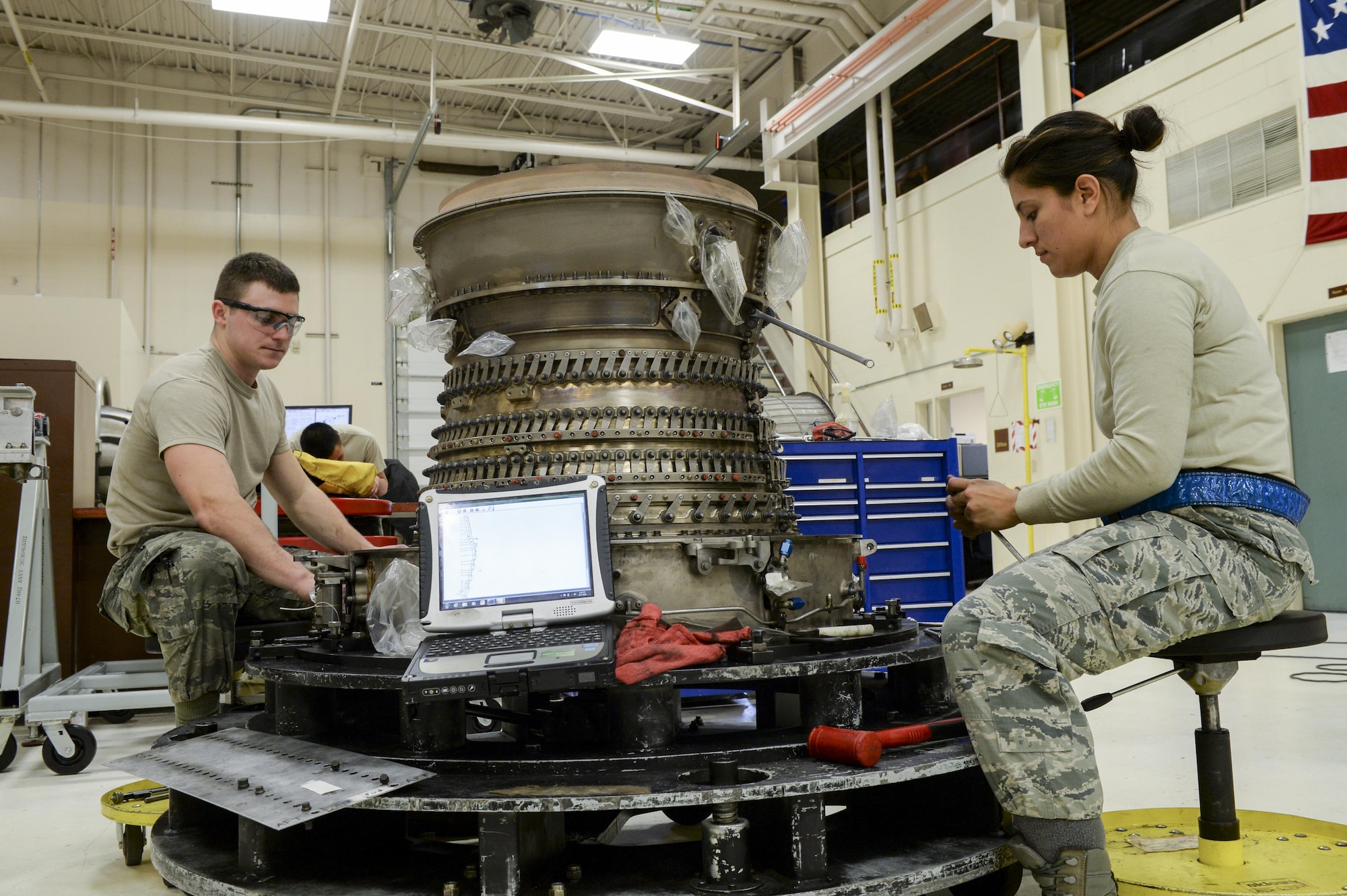 U.S. Air Force Senior Airman Cody Bowman, an aerospace propulsion journeyman, and Staff Sgt. Catalina Cornejo, an aerospace propulsion craftsman, both assigned to the 354th Maintenance Squadron, disassemble an F110-GE-100C jet engine Oct. 8, 2015, during an engine rebuild in the Engine Shop at Eielson Air Force Base, Alaska. Bowman and Cornejo conducted an engine rebuild to find and replace any worn components. (U.S. Air Force photo by Senior Airman Peter Reft/Released)