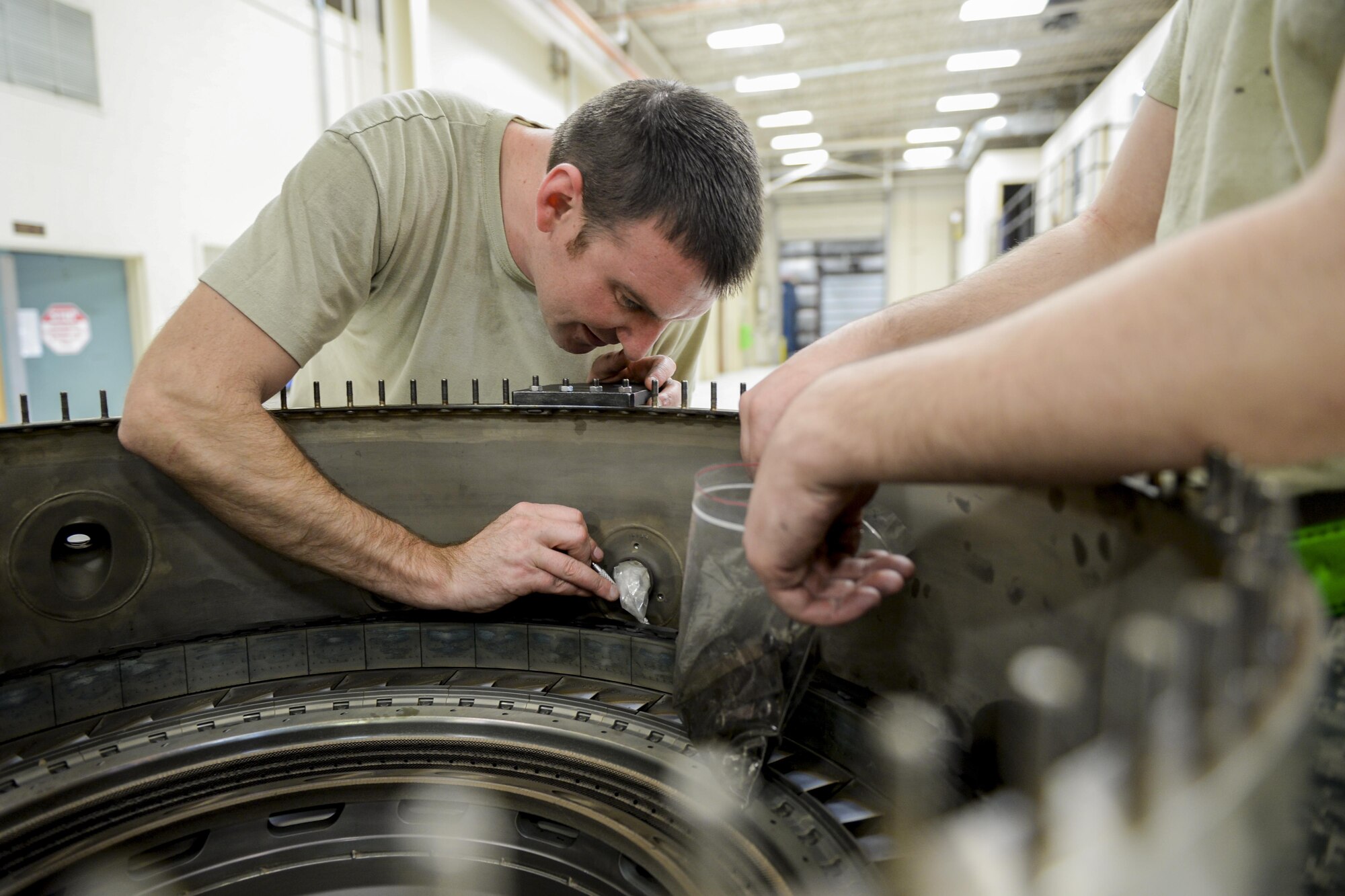 U.S. Air Force Staff Sgt. Jonathan Royder, a 354th Maintenance Squadron aerospace propulsion craftsman, extracts bolts from a combustion diffuser nozzle assembly Oct. 8, 2015, in the Engine Shop at Eielson Air Force Base, Alaska. Royder serviced the jet engine as part of an engine rebuild involving a complete tear down and inspection of all parts. (U.S. Air Force photo by Senior Airman Peter Reft/Released)