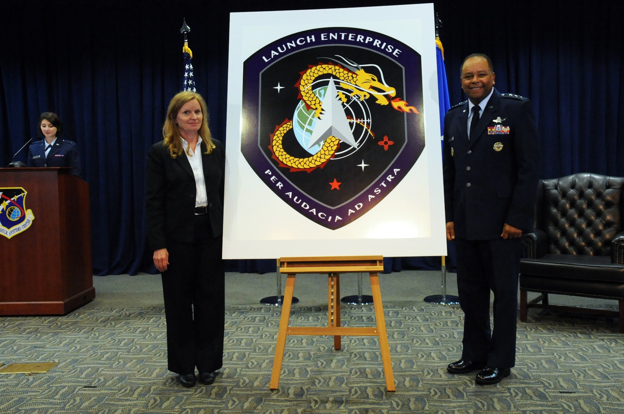 Lt. Gen. Samuel Greaves, Space and Missile Systems Center commander and Air Force Program Executive Officer for Space and Dr. Claire Leon, the first director of the Launch Systems Enterprise Directorate unveil the new emblem during a brief stand up ceremony, Oct. 14. The Latin phrase, "Per Audacia Ad Astra" translates to "Through boldness to the stars" -- the new motto of the Launch Enterprise Directorate. (U.S. Air Force photo/Van De Ha)