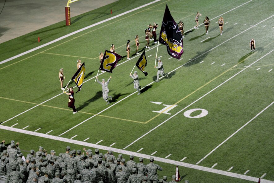 Airmen from Sheppard Air Force Base, Texas, wave the flags of the Midwestern State University after Vincent Jackson, Mustangs running back, put a stamp on the win over West Texas A&M with an 84-yard touchdown run in the fourth quarter, 24-17. Sheppard Airmen and Soldiers from Ft. Sill, Okla., were invited to the military appreciation game to cheer on the Mustangs in their 24-17 win over West Texas A&M. (U.S. Air Force photo/Tech. Sgt. Mike Meares)