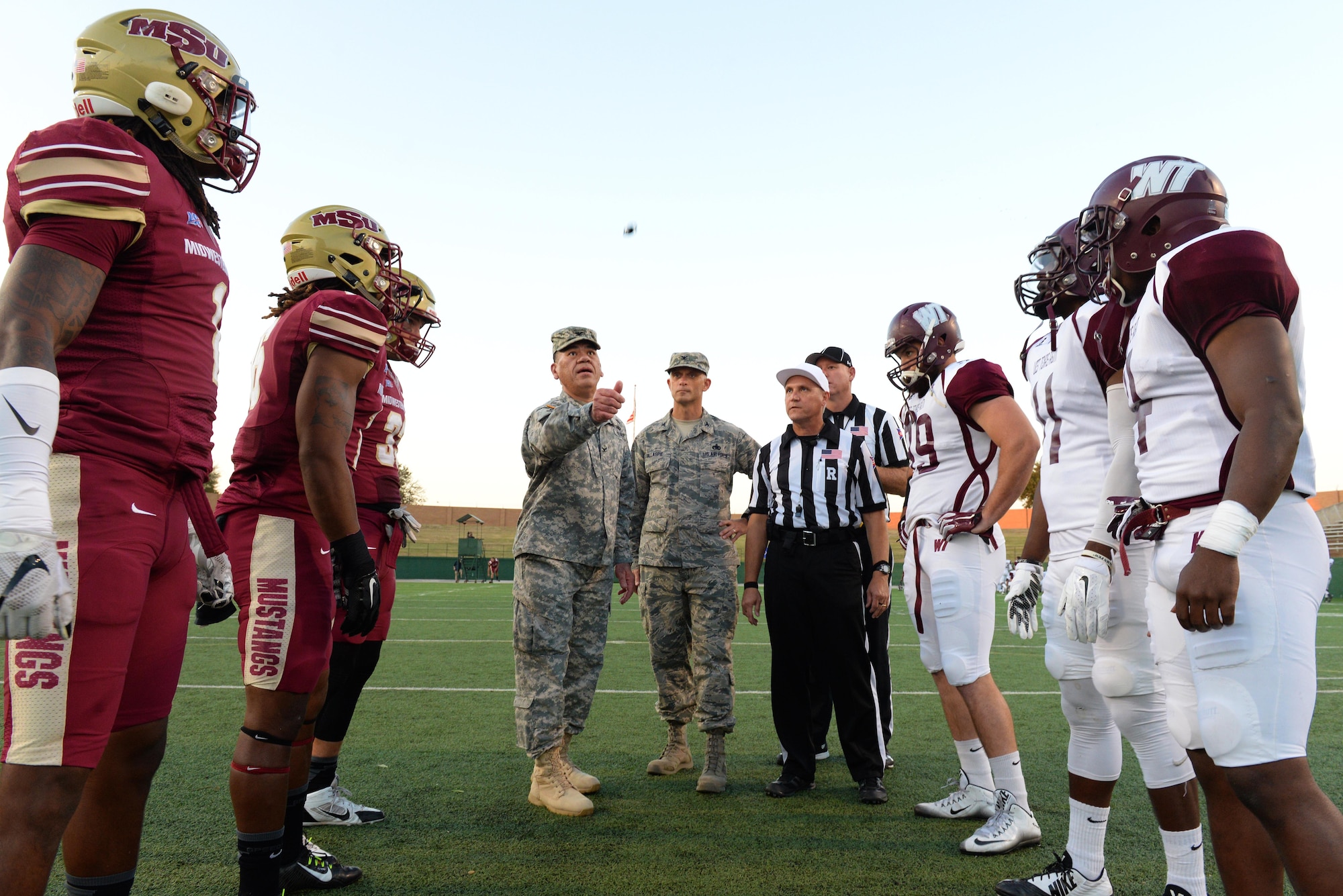 Col. William Darne, G-3 Fires Center of Excellence, Fort Sill, Okla., and Col. Timothy Gillaspie, 82nd Training Wing Vice commander, Sheppard Air Force Base, Texas, joined the captains of the Midwestern State University and West Texas A&M football teams for the coin flip at midfield of the Wichita Falls Memorial Stadium Oct. 10, 2015. Sheppard Airmen and Soldiers from Ft. Sill, Okla., were invited to the military appreciation game to cheer on the Mustangs in their 24-17 win over West Texas A&M. (U.S. Air Force photo/Tech. Sgt. Mike Meares)
