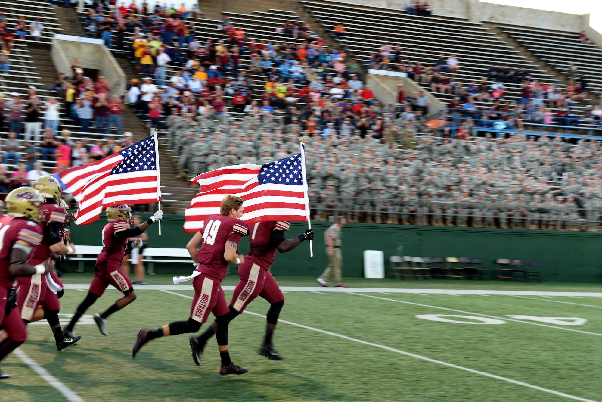 Midwestern State University Mustangs football players storm the field during pre-game introductions during the home game against West Texas A&M Oct. 10, 2015, at the Wichita Falls Memorial Stadium, Texas. Sheppard Airmen and Soldiers from Ft. Sill, Okla., were invited to the military appreciation game to cheer on the Mustangs in their 24-17 win over West Texas A&M. (U.S. Air Force photo/Tech. Sgt. Mike Meares)