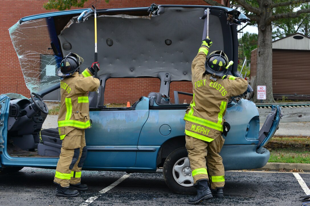 Fort Eustis Fire Department fire and emergency services firefighters and paramedics lift the roof off a car during a Fire Prevention Week presentation at Fort Eustis, Va., Oct. 10, 2015. As the firefighters took the vehicle apart, they briefed the audience on their methods and tools. (U.S. Air Force photo by Staff Sgt. Natasha Stannard/Released)