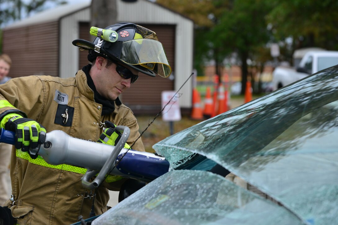 Tim Murphy, Fort Eustis Fire Department fire and emergency services firefighter and paramedic, uses the Jaws of Life to take apart a vehicle during Fire Prevention Week at Fort Eustis, Va., Oct. 10, 2015. The firefighters tore the car apart to show parents and children how they would respond to a vehicle accident. (U.S. Air Force photo by Staff Sgt. Natasha Stannard/Released)