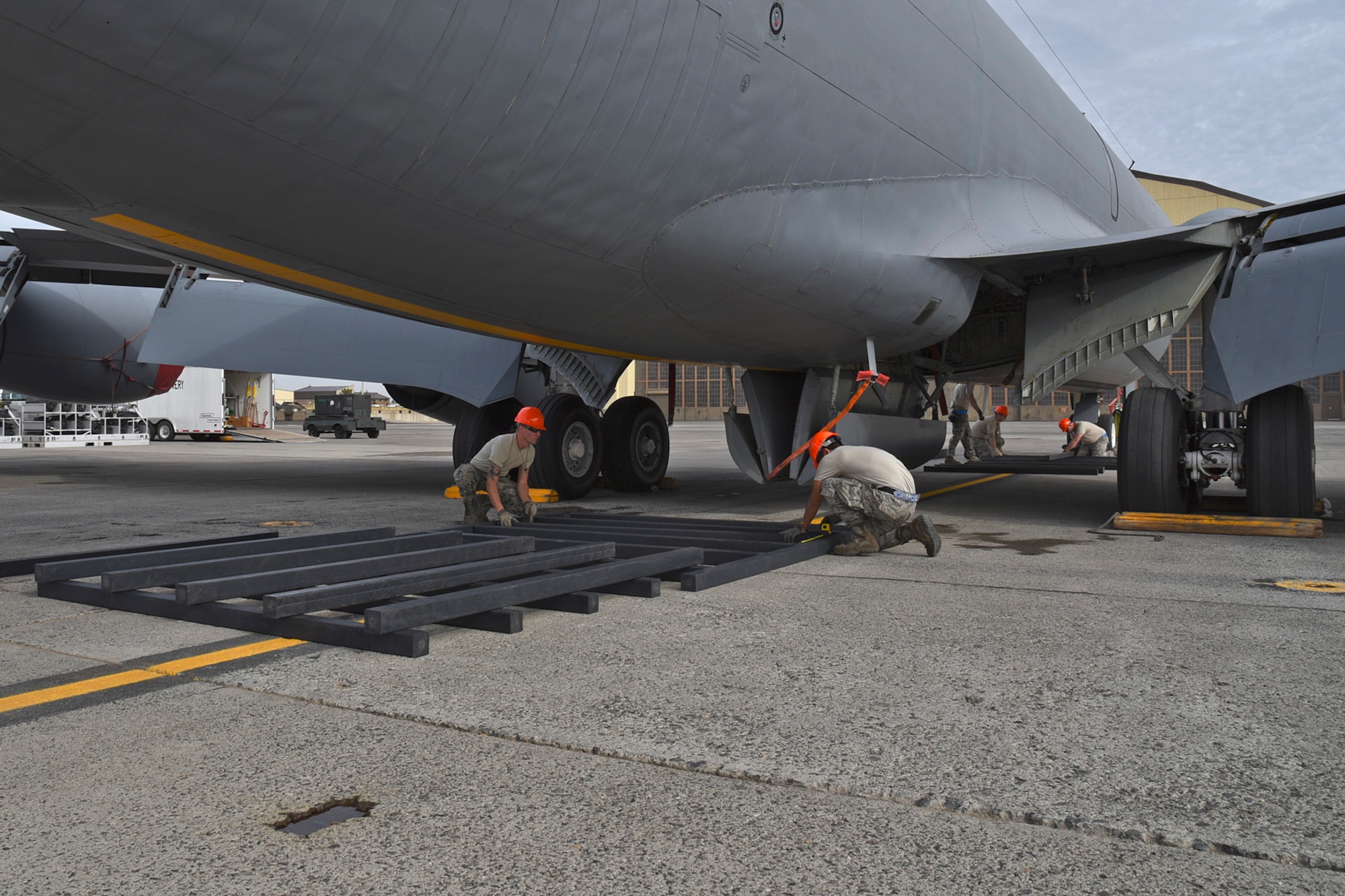 92nd Maintenance Squadron Airmen lay out synthetic dunnage in preparation for a Crash, Damaged, Disabled Aircraft Recovery training lift Oct. 9, 2015, at Fairchild Air Force Base, Wash. Airmen created platforms using synthetic dunnage in four separate locations under the aircraft. The platforms were of various heights, depending on the section of the aircraft they supported. After the platforms were constructed, the team then laid pallets and finally airbags on top of the platforms.  (U.S. Air Force photo/Airman 1st Class Mackenzie Richardson)