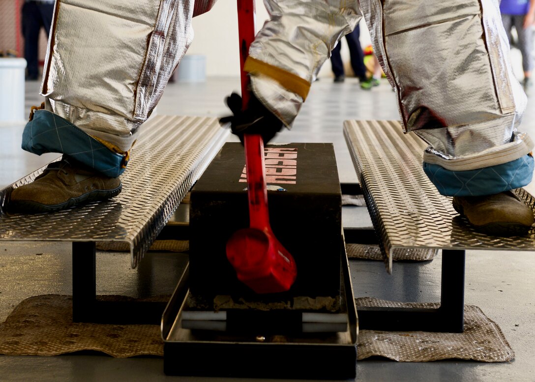 A U.S. Air Force Airman hits a block of steel with a hammer during the Firefighter Challenge at Langley Air Force Base, Va., Oct. 9, 2015. Airmen wielded a 10-pound hammer to move the 160-pound sled before continuing onto the next event. (U.S. Air Force photo by Airman 1st Class Derek Seifert/ Released) 
