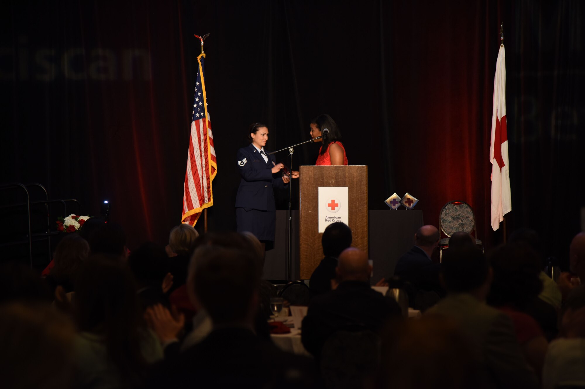 Staff Sgt. Mandy Morris, 62nd Maintenance Squadron precision measurement equipment laboratory craftsman, accepts the Water Rescue award on behalf of Senior Airman Joshua Calhoun, 62nd MXS PMEL journeyman, during the 2015 American Red Cross’ Heroes luncheon at Hotel Murano’s Bicentennial Pavilion in Tacoma, Wash., Oct. 13, 2015. Calhoun, who is deployed, provided Morris with a statement which included that he is honored to accept the award, he wished he could have accepted the award in person, and stated that everyone should be excellent to one another because of the impact it could make on another’s life.