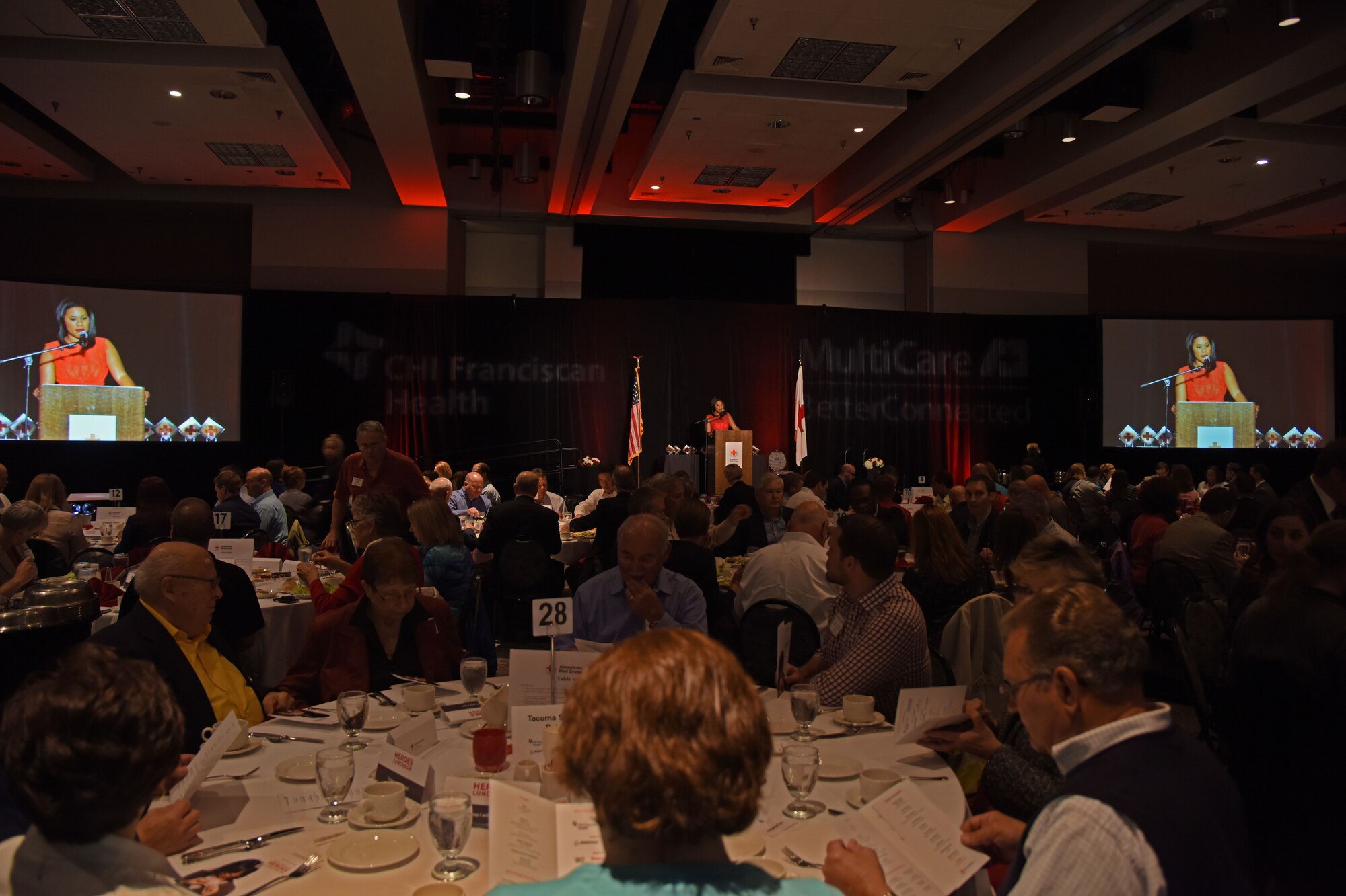 Jenna Hanchard, KING-5 news reporter and event host, welcomes all attendees to the American Red Cross’ 22nd annual Heroes luncheon at Hotel Murano’s Bicentennial Pavilion in Tacoma, Wash., Oct. 13, 2015, an event that recognizes heroes who reacted quickly and courageously to save a life, to prevent a tragedy, or unselfishly gave themselves for the greater good, regardless of personal risks. Senior Airman Joshua Calhoun, 62nd Maintenance Squadron precision measurement equipment laboratory journeyman, was recognized in the category of Water Rescue for saving surfer’s life earlier this year. (U.S. Air Force photo/Staff Sgt. Katie Jackson)