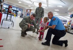 Joint Base Charleston Fire Department firemrn show visitors how to properly put out fires with a fire simulation game during a fire prevention week event Oct. 6, 2015, at the Base Exchange on JB Charleston – Air Base, S.C. Fire prevention week was Oct. 4 through Oct. 10 and the JB Charleston Fire Department hosted several events around the Air Base and Weapons Station. Fire prevention week was established in 1925 by President Calvin Coolidge when close to 15,000 American citizens died in fires the previous year. (U.S. Air Force photo/Airman 1st Class Clayton Cupit)