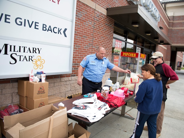 A Joint Base Charleston Fire Department fireman gives out popcorn to visitors during a fire prevention week event Oct. 6, 2015, at the Base Exchange on JB Charleston – Air Base, S.C. Fire prevention week was Oct. 4 through Oct. 10 and the JB Charleston Fire Department hosted several events around the Air Base and Weapons Station. Fire prevention week was established in 1925 by President Calvin Coolidge when close to 15,000 American citizens died in fires the previous year. (U.S. Air Force photo/Airman 1st Class Clayton Cupit)