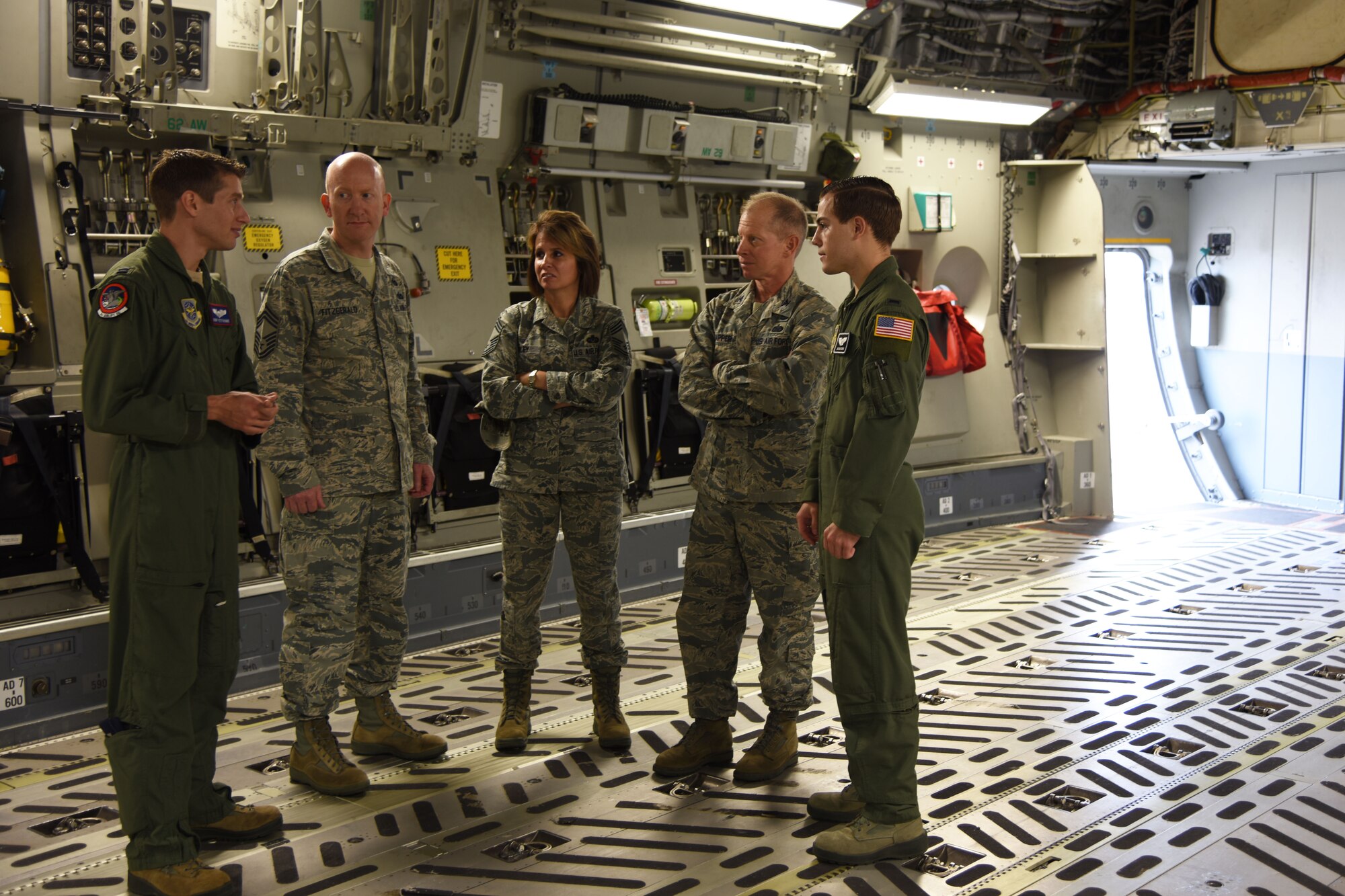 Pilots from the 4th and 8th Airlift Squadrons brief Col. James Dapper (middle right), Air Mobility Command staff judge advocate, Chief Master Sgt. Catrin Wiley (middle), 18th Air Force paralegal manager, and Chief Master Sgt. Steven Fitzgerald (middle left), AMC command paralegal manager, about the various missions and capabilities of the C-17 Globemaster III aircraft at McChord Field, Wash., Oct. 8, 2015. Starting in October, Dapper and senior paralegals began a series of visits to AMC installations with specific goals to include assessing what the host legal team needs, learning about uniquely challenging legal issues, observing the climate in terms of energy and opportunity for innovation, and assessing the potential of team members to succeed in positions of greater responsibility. (U.S. Air Force photo/Staff Sgt. Katie Jackson)