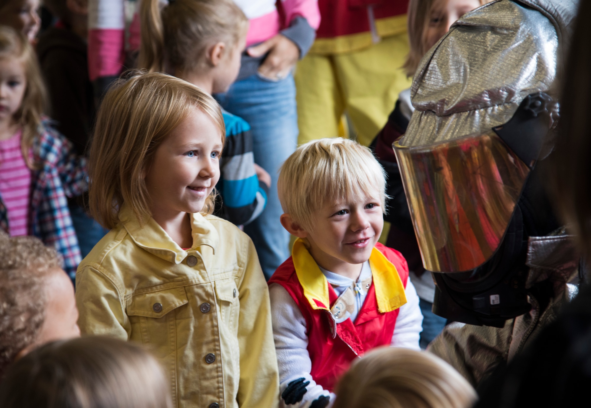 Children look at a firefighter in his suit during fire prevention week, October 5, 2015, at the Patriots Landing Fire Station. Fire prevention week helps not only teaches children about preventing fires but also what steps to take in the event of a fire. (U.S. Air Force photo by Airman Gwendalyn Smith)