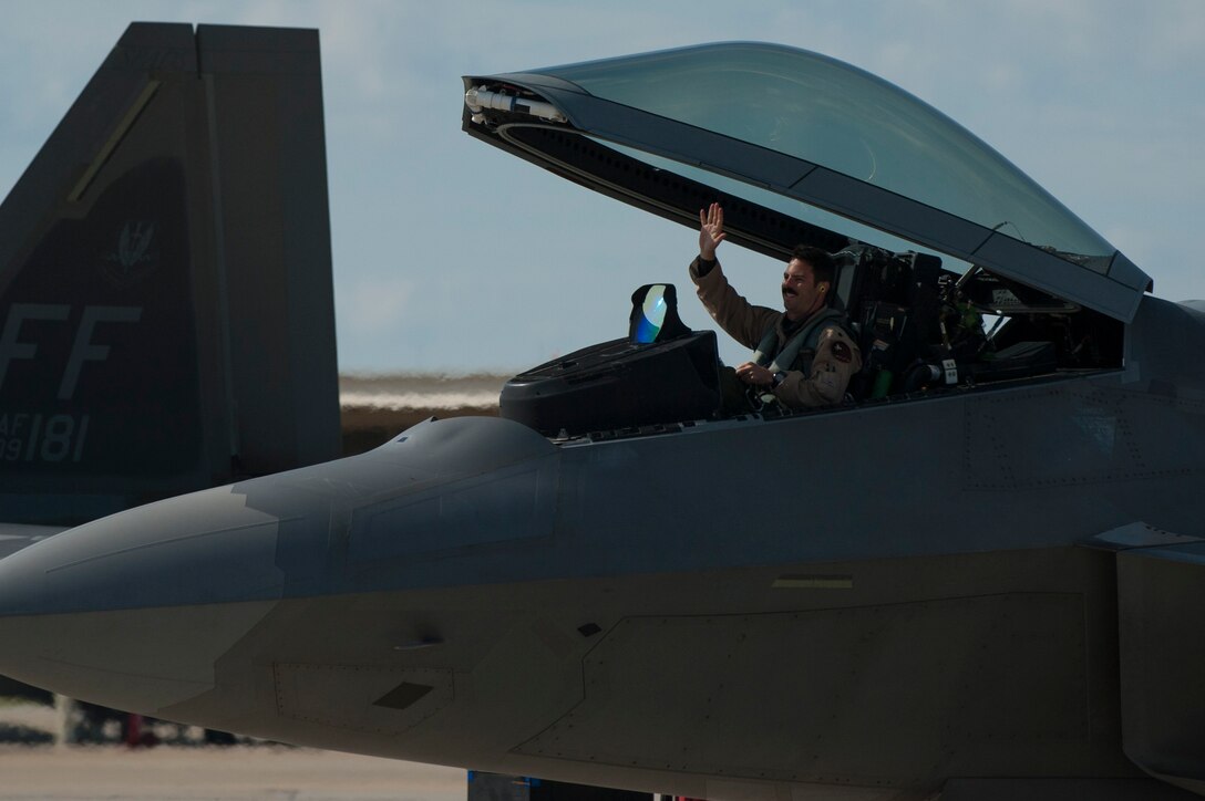 A U.S. Air Force Airman with the 1st Fighter Wing waves to family and friends upon returning from a deployment at Langley Air Force Base, Va., Oct. 9, 2015.  The Airmen from Joint Base Langley-Eustis supported Operation Inherent Resolve as a part of a theater security package throughout Syria and Iraq. (U.S. Air Force photo by Staff Sgt. Natasha Stannard/Released)