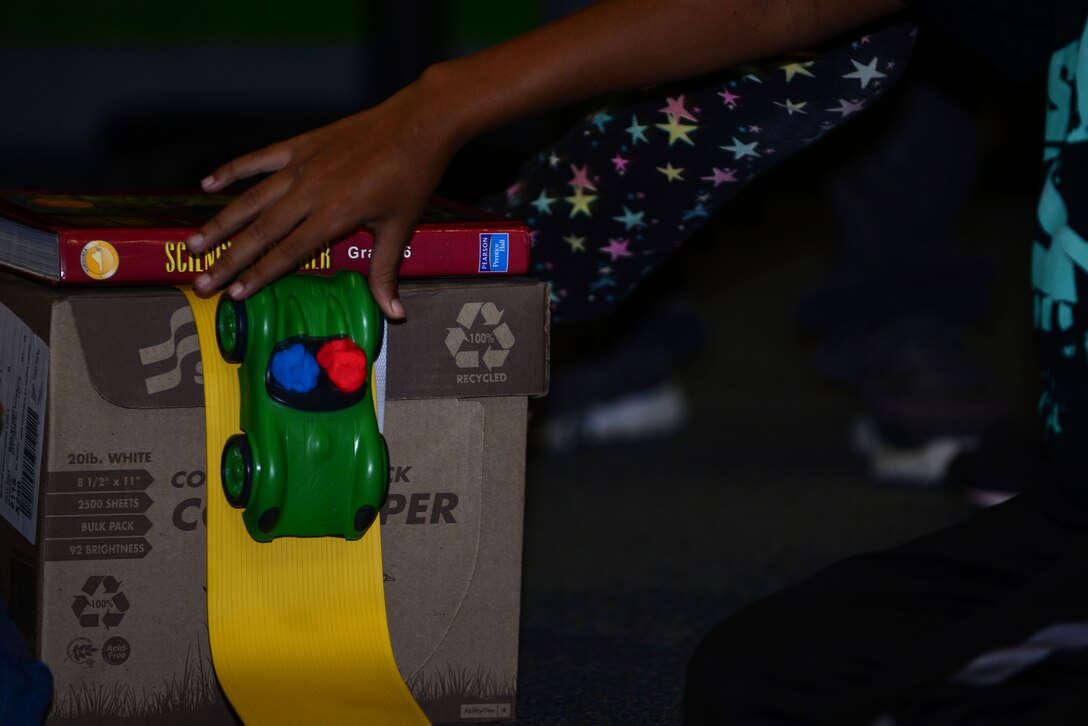 A toy car is guided down a track by a Joint Base Langley-Eustis Youth Program participant as part of 4-H National Youth Science Day at Fort Eustis, Va., Oct. 7, 2015. According to the 4-H website, NYSD is the world’s largest youth-led science experiment. (U.S. Air Force photo by Senior Airman Kimberly Nagle/Released)