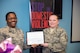 U.S. Air Force Maj. Amanda Sims-High, 23d Medical Group Family Advocacy officer, presents Tech. Sgt. Katherine Gay, 23d Medical Support Squadron medical laboratory technician, with a plaque for her role in the Breast Cancer and Domestic Violence Awareness luncheon Oct. 8, 2015, at Moody Air Force Base, Ga. Gay shared her experience as a domestic violence survivor with guests in attendance.  (U.S. Air Force photo by Airman 1st Class Greg Nash/Released)  