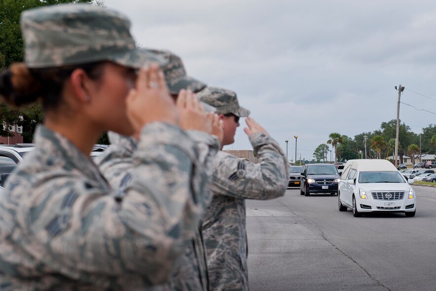 Senior Airman Marisol Ortiz Flores, 96th Logistics Readiness Squadron, salutes to pay respect to a fallen Airman during his journey home by motorcade Oct. 13 at Eglin Air Force Base, Fla.  The fallen defender, Senior Airman Nathan Sartain, 66th Security Forces Squadron, was flown to Eglin and driven to his hometown of Pensacola.  Sartain was one of six Airmen killed in a C-130J crash Oct. 2 in Jalalabad Afghanistan.  (U.S. Air Force photo/Ilka Cole)