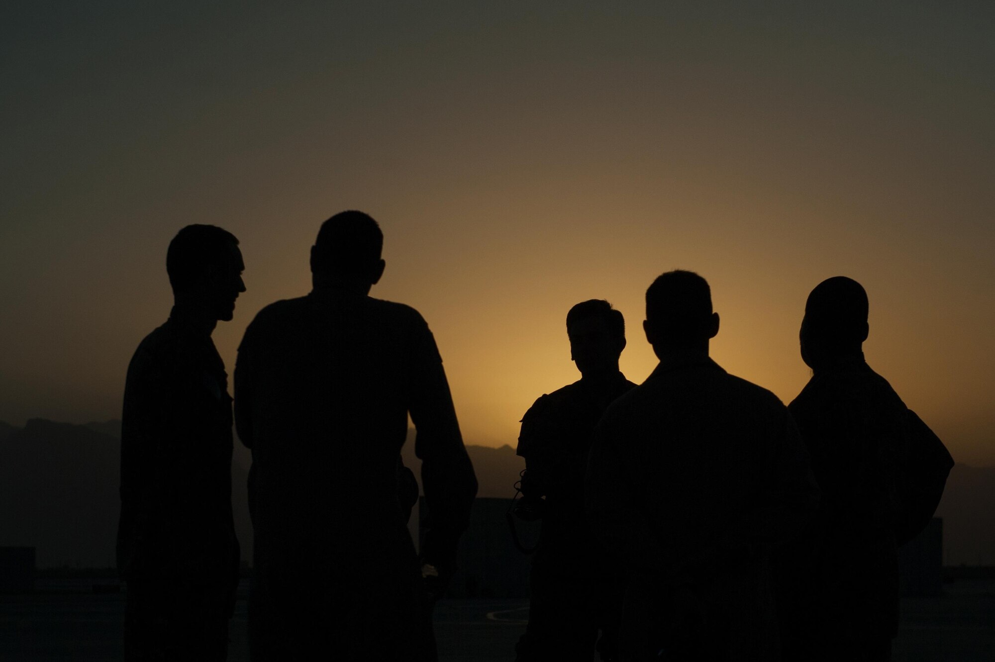 U.S. Airmen assigned to the 41st Expeditionary Electronic Combat Squadron talk during an EC-130H Compass Call aircraft final mission meeting on the flight line at Bagram Air Field, Afghanistan, Sept. 6, 2015. The Compass Call is an airborne tactical weapon system using a heavily modified version of the C-130 Hercules airframe. (U.S. Air Force photo by Tech. Sgt. Joseph Swafford/Released)