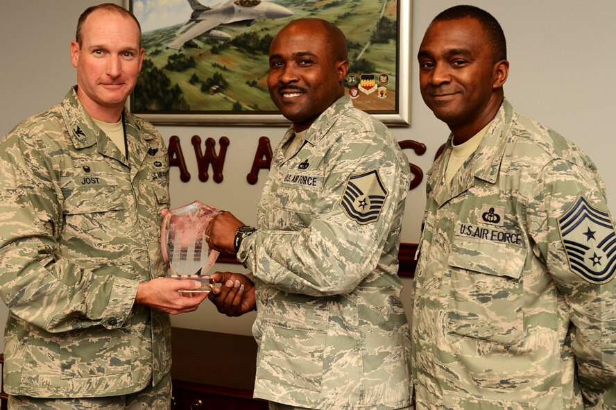 U.S. Air Force Master Sgt. Christopher Cohen, 20th Logistics Readiness Squadron vehicle operations section chief, receives the Air Combat Command Program Manager of the Year award from Col. Stephen Jost, 20th Fighter Wing commander, and Chief Master Sgt. Christopher McKinney, 20th FW command chief, at Shaw Air Force Base, S.C., Oct. 14, 2015. Cohen won the award for his leadership of the 20th Force Support Squadron Honor Guard. (U.S. Air Force photo by Senior Airman Jonathan Bass/Released)
