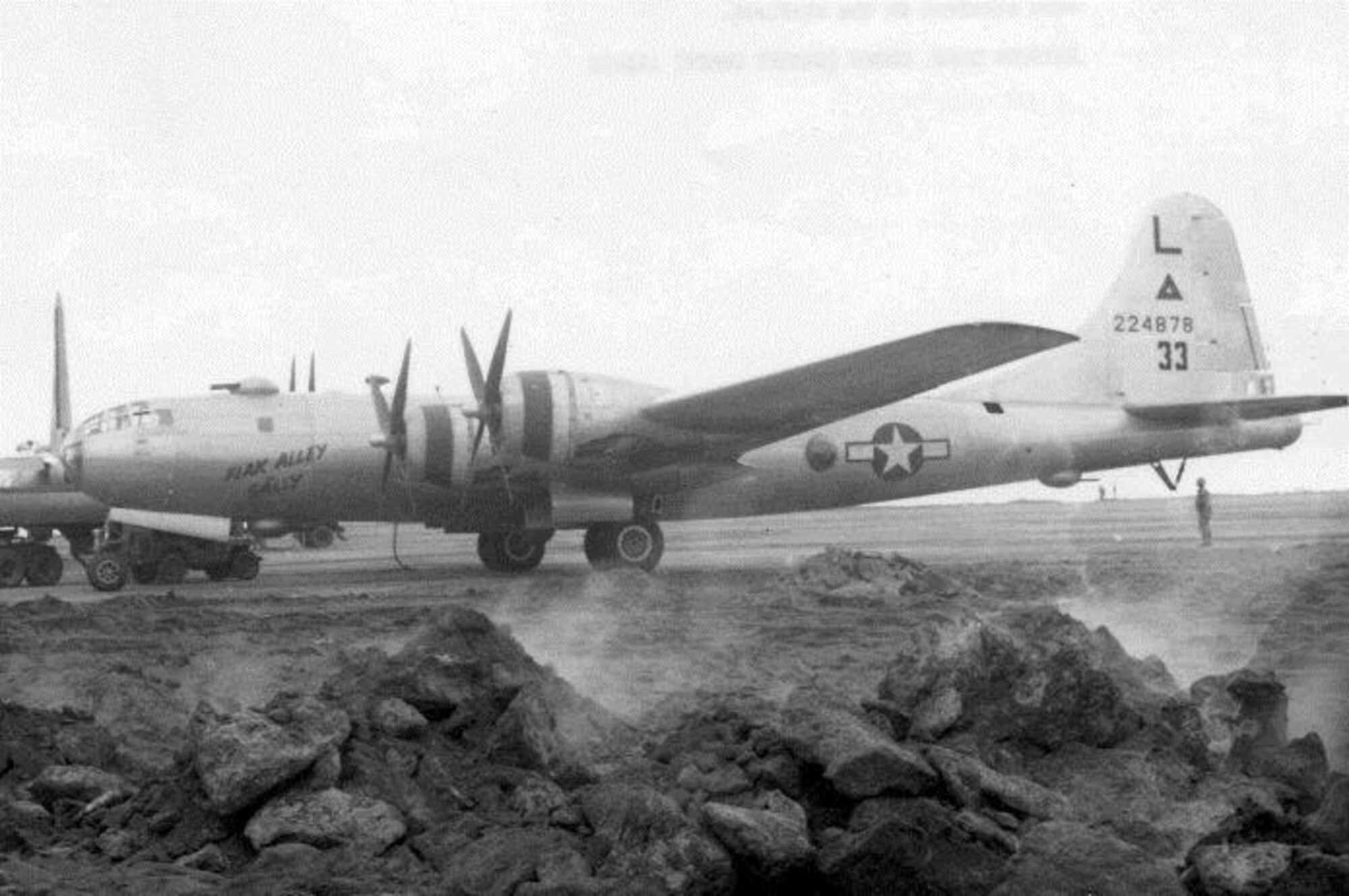 Pictured here at Iwo Jima in 1945, “Flak Alley Sally,” was a Superfortress assigned to the 40th Bomb Squadron, a B-29-55-BW, serial number 42-24878.  Seen here refueling at Iwo Jima in 1945 following a raid on the Empire, she bears the early markings of the group with the “L” (6th Bomb Group identification letter) above a triangle (313th Bomb Wing identification symbol) above the aircraft serial number.  The “33” is an early Victor number (group/squadron aircraft identification number also used as a radio call sign number), which was later moved to the rear fuselage and changed to “53.” (Courtesy 6th Bomb Group Association)