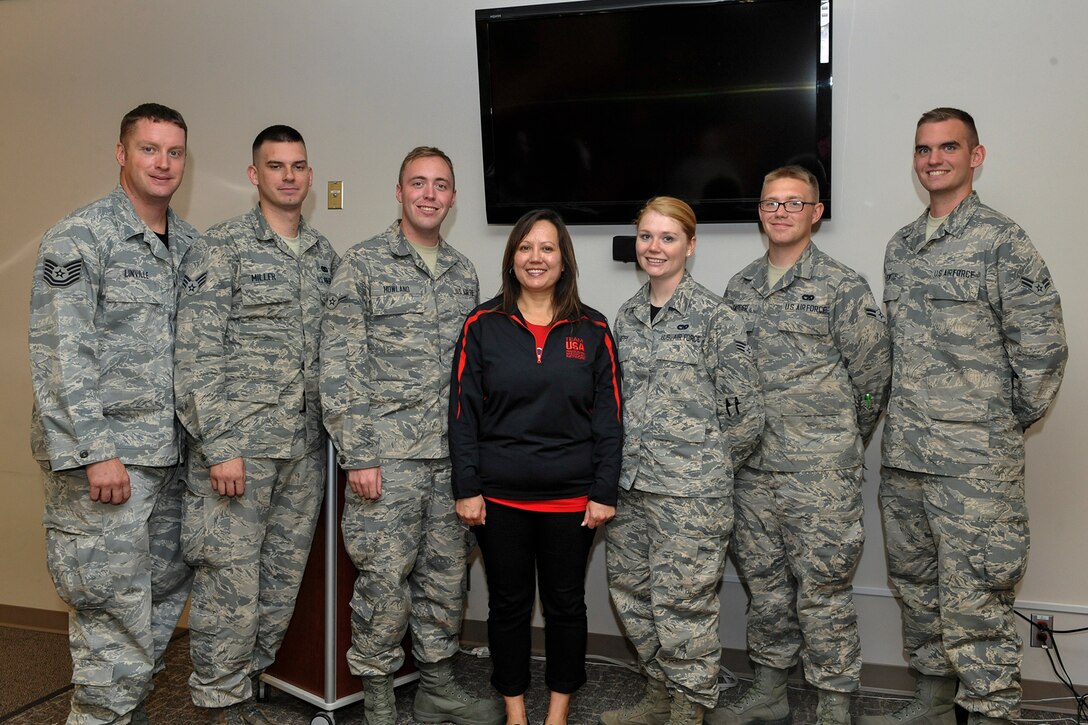 PETERSON AIR FORCE BASE, Colo. -- Christine Johnson, associate director of sports medicine for the U.S. Olympic Committee, center, presented certificates and coins to Airmen from the 21st Logistics Readiness Squadron, Oct. 2, 2015. The Airmen were recognized for volunteering their time in organizing and building pallets of medical supplies for the U.S. Olympic committee. (U.S. Air Force Photo by Philip Carter)