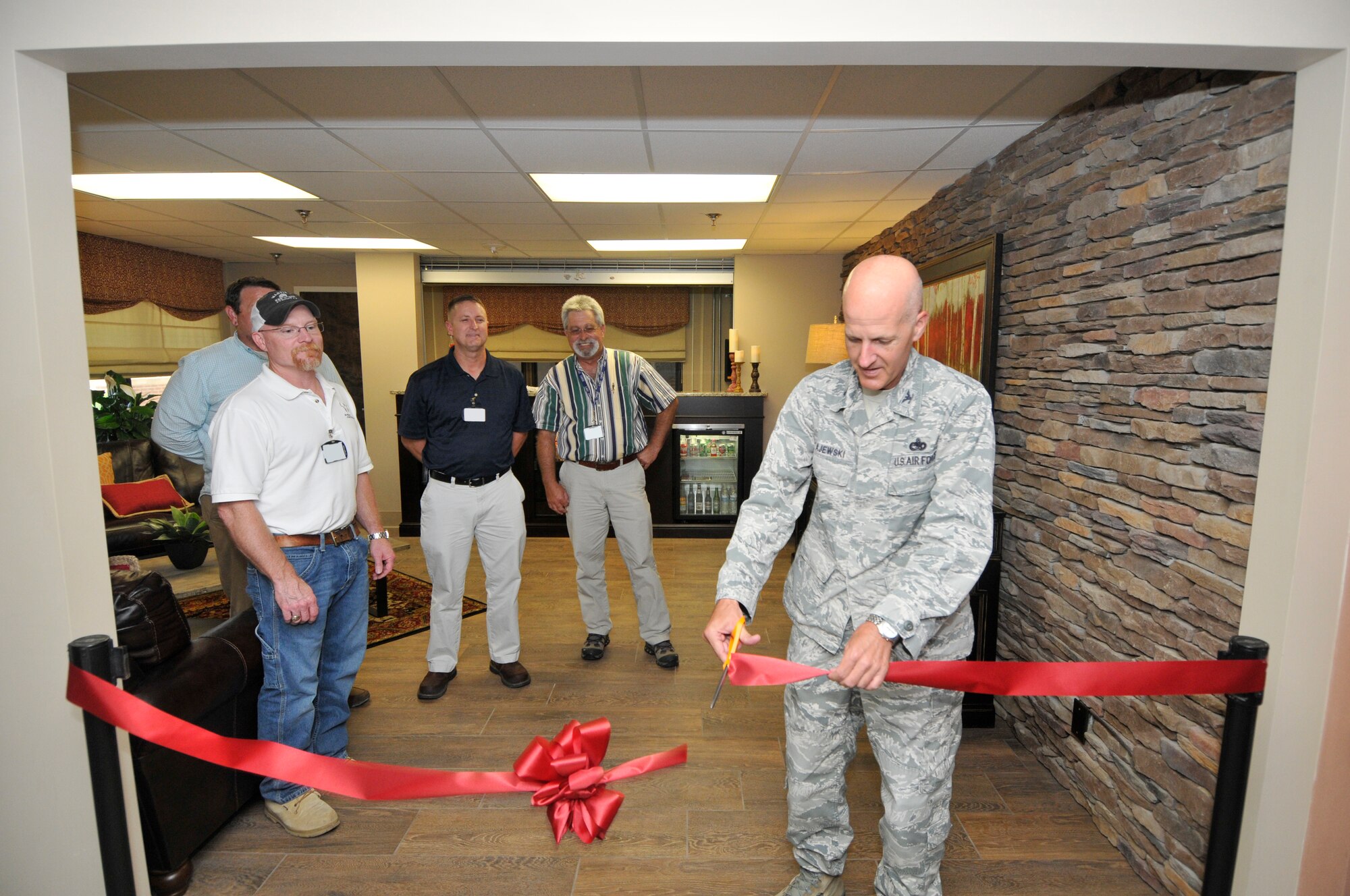 Col. James Krajewski (far right), Director of the AEDC Test Support Division, cuts a ribbon commemorating the renovation completion of the Wingo Inn guest lobby on June 17. The guest lobby has been undergoing construction since December 8, 2014. Wingo Inn is located on the shores of Woods Reservoir at Arnold Air Force Base and offers lodging for all military ranks. Pictured left to right are the AEDC team members who helped in the renovation process, Robert Greene and David Wilhite; and Chris Anderson, contractor over the renovation project with Warden Construction Co. (Photo by Jacqueline Cowan)

-AEDC-
