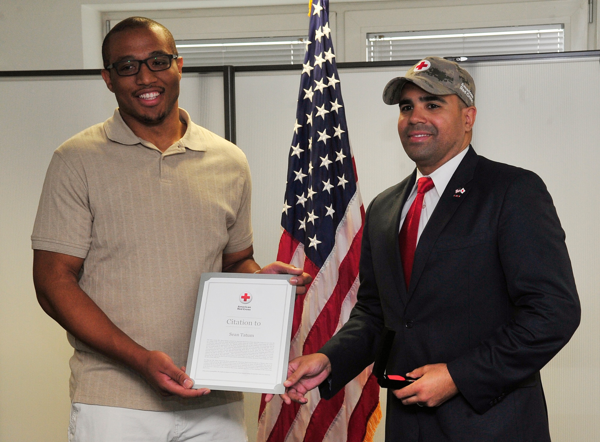 Sean Tatum, 86th Force Support Squadron caregiver, and Koby Langley, senior vice president of Service to the Armed Forces, pose for a photo during a Red Cross Lifesaver Award ceremony Oct. 8, 2015, at Ramstein Air Base, Germany. Tatum was presented the Red Cross Lifesaver Award for the actions he took July 1, 2015, to save a child who was choking. (U.S. Air Force photo/Airman 1st Class Larissa Greatwood)