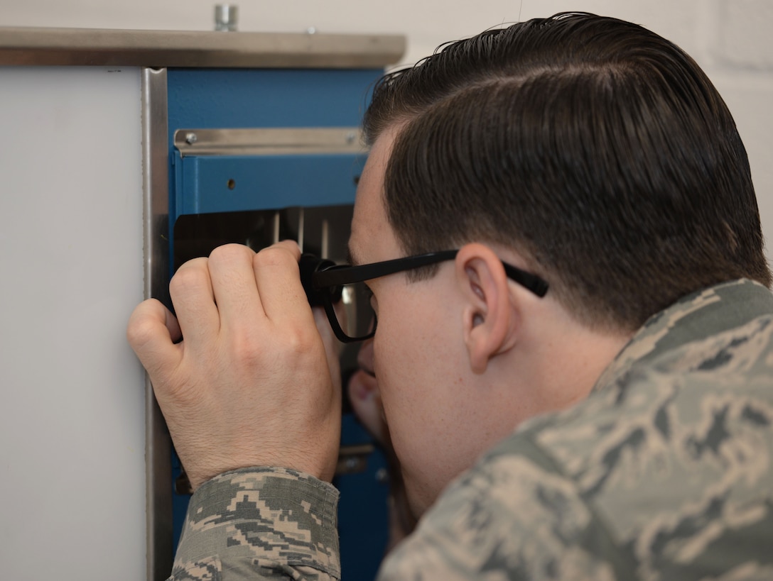 U.S. Air Force Staff Sgt. Anthony Sweat, 100th Maintenance Squadron nondestructive inspection journeyman, uses a specialized optical lens Sept. 2, 2015, on RAF Mildenhall, England. Using these lens means he’s able to measure and pinpoint specific discontinuities on radiographic film for weld certifications. (U.S. Air Force photo by Gina Randall/Released)