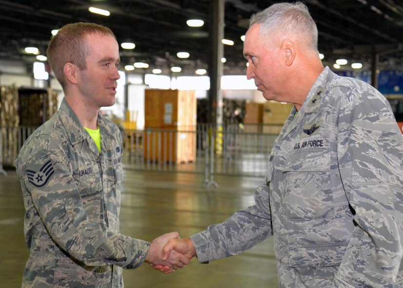 U.S. Air Force Maj. Gen. Frederick H. Martin, right, U.S. Air Force Expeditionary Center commander, coins U.S. Air Force Staff Sgt. Daniel Kraus, 727th Air Mobility Squadron air freight technician, during a visit Oct. 9, 2015, on RAF Mildenhall, England. Martin visited the 727th AMS along with U.S. Air Force Col. Nancy Bozzer, 521st Air Mobility Operations Wing commander, Ramstein Air Base, Germany, and other Air Mobility Command leadership, and coined several individuals for superior performance. (U.S. Air Force photo by Karen Abeyasekere/Released)