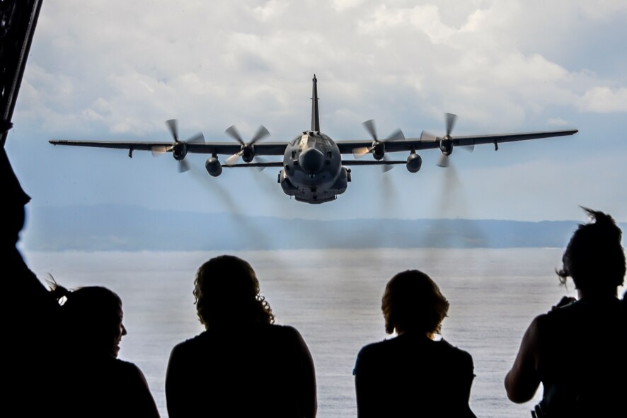 Spouses from the 353rd Special Operations Group watch an MC-130H Combat Talon II follow them in a flight formation as part of a spouse orientation day Oct. 8, 2015, off the coast of Okinawa, Japan. Spouses of special operations Airmen often times spend an extended period of time away from their husbands and wives due to mission requirements. The orientation flight, along with various other activities, gave the spouses an opportunity to have a firsthand look at the group’s daily operations. (U.S. Air Force photo by Senior Airman John Linzmeier)