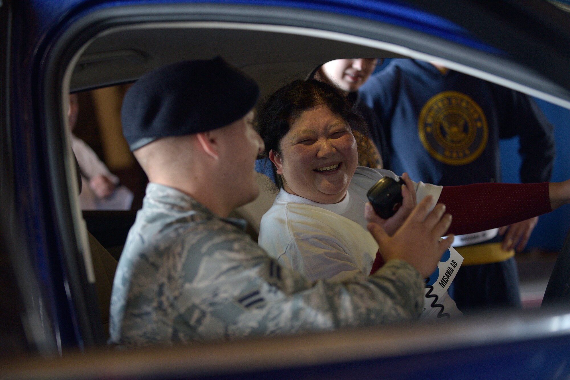 U.S. Air Force Airman 1st Class Jonathan Rogers, 35th Security Forces Squadron installation entry controller, shows a Olympics participant how to utilize the external speaker on an emergency response vehicle at Misawa Air Base, Japan, Oct. 10, 2015. Members from the 35 SFS and 35 Civil Engineer Squadron explosive ordnance disposal flight were present at the event to show the athletes equipment they work with. (U.S. Air Force photo by Senior Airman Jose L. Hernandez-Domitilo/Released)