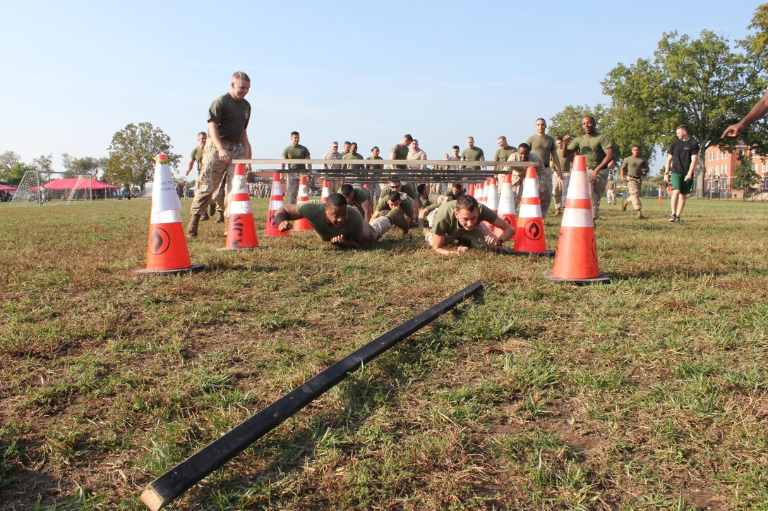 Marines low crawling in the zombie gauntlet portion of the CFC kick-off field meet, held aboard Marine Corps Base Quantico.