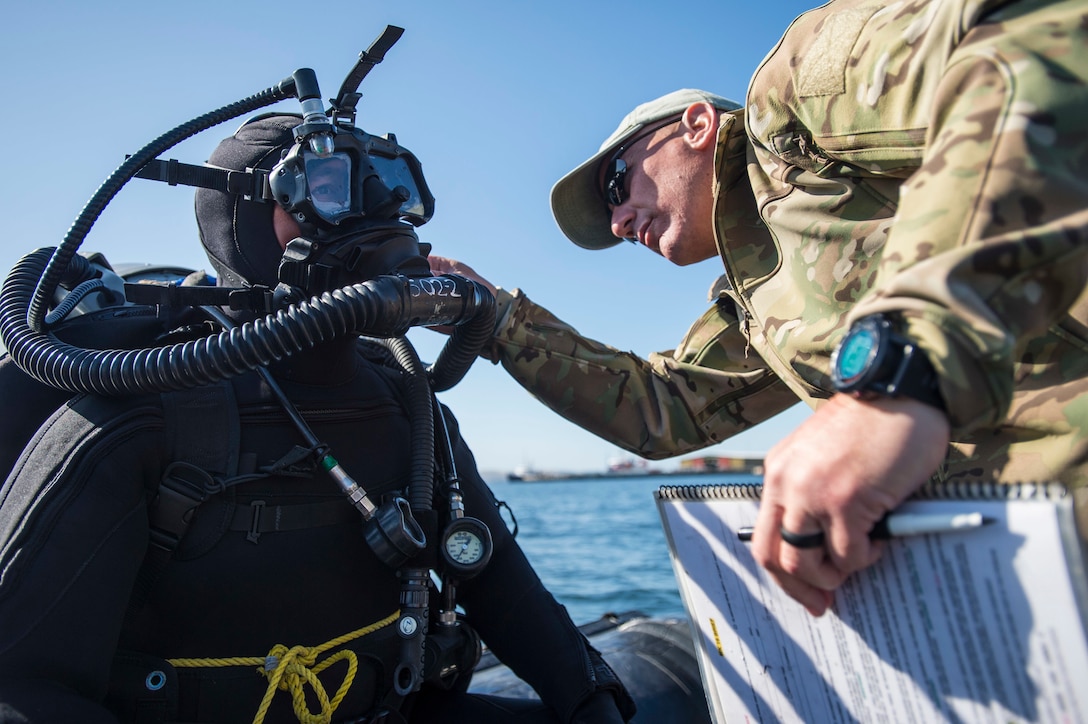 U.S. Navy Senior Chief Petty Officer Bill Stocker, right, checks equipment on Seaman John Dirks during exercise Dugong 2015 near Hobart, Australia, Oct. 7, 2015. Stocker and Dirks are assigned to Explosive Ordnance Disposal Mobile Unit 5. U.S. Navy photo by Petty Officer 2nd Class Daniel Rolston