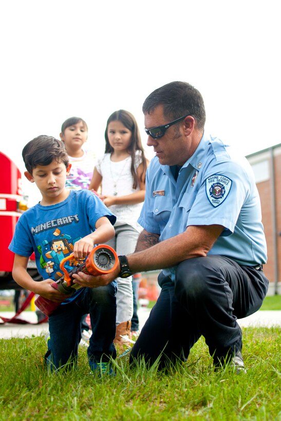 Patrick Vaughn, Fire Station 533 fireman, demonstrates how to use a 100-foot fire hose at Crossroads Elementary School during Fire Safety Week, Oct. 7. Children learned simple tools for a safe home and how to react in an emergency.