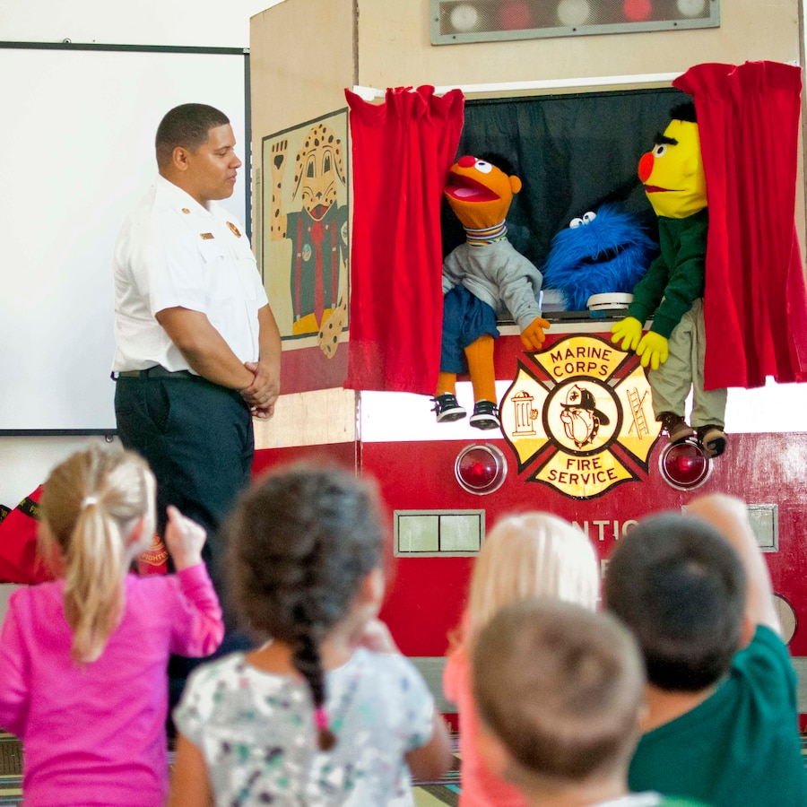 Leon Hughes, fire inspector, greets the children at the Child Development Center during Fire Safety Week, Oct. 9. Firefighters and fire inspectors worked together throughout the week to share safety tips with children.