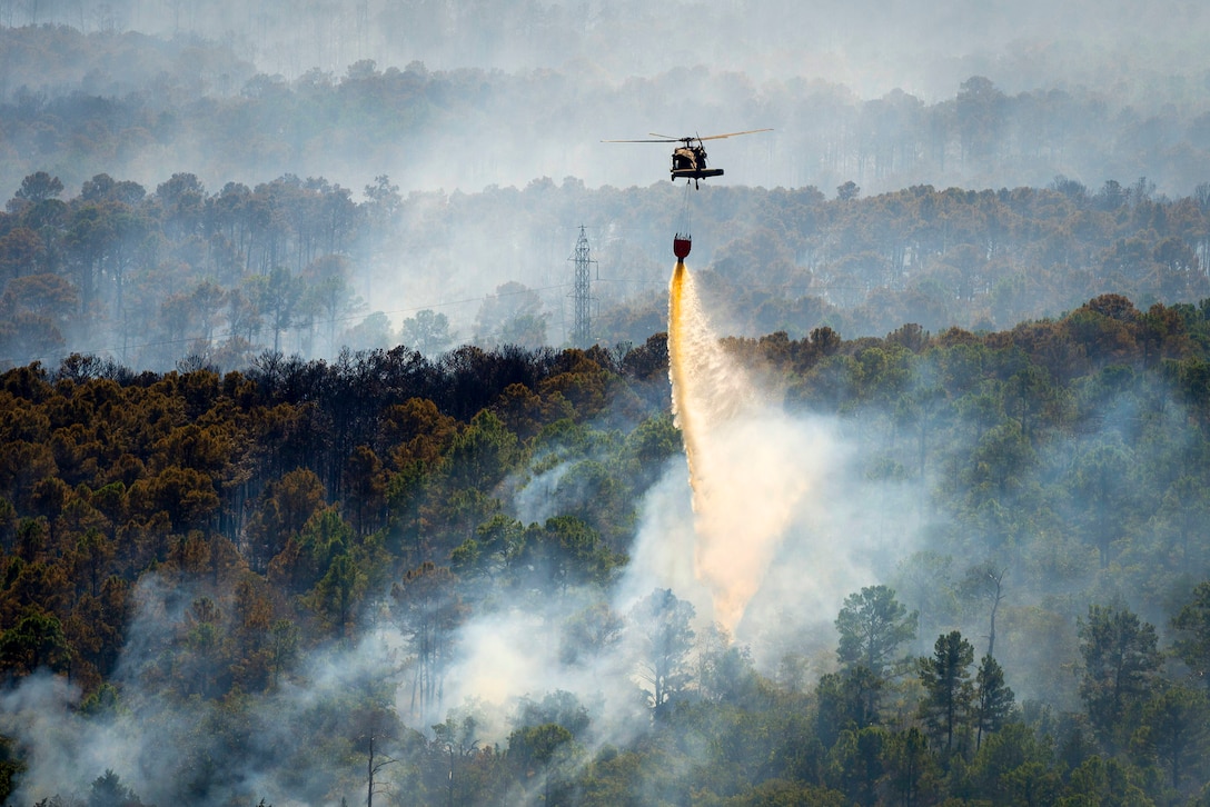 A Texas Army National Guard UH-60 Black Hawk helps fight wildfires threatening homes and property near Bastrop, Texas, Oct. 14, 2015. U.S. Army National Guard photo by Sgt. 1st Class Malcolm McClendon