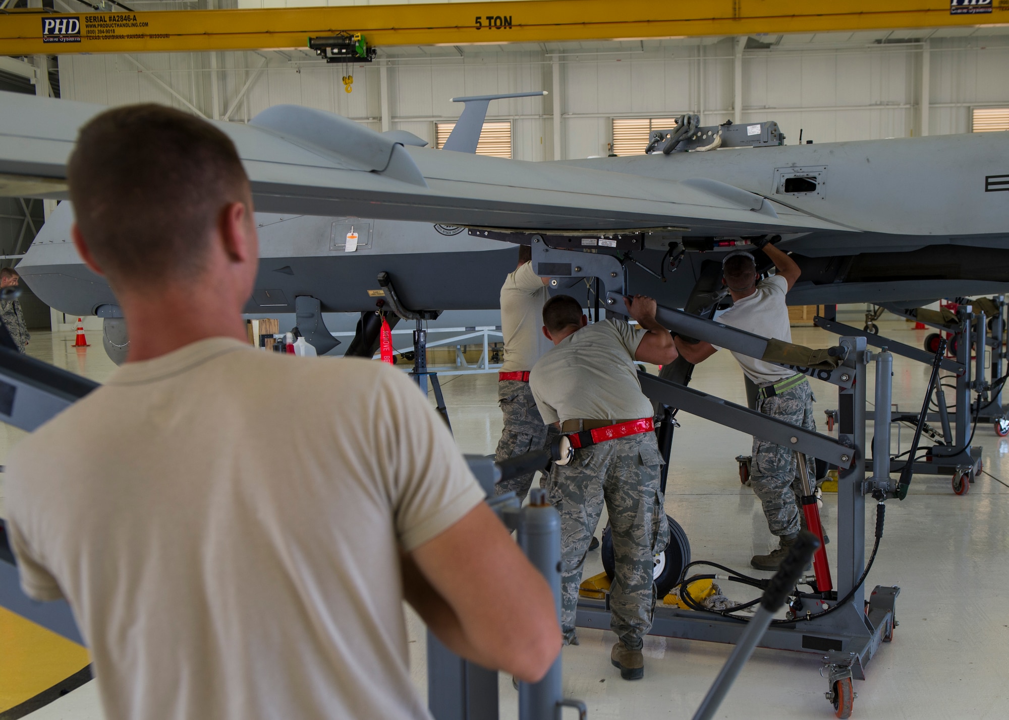 Senior Airman Daniel Hawley, an MQ-9 Reaper crew chief with the 49th Aircraft Maintenance Squadron, aligns the left wing of an MQ-9 at Holloman Air Force Base, N.M., Oct. 13, 2015. Putting the wings on the MQ-9 is a tedious process which involves aligning pins perfectly to ensure the wings are stabilized. The wings were replaced as part of an upgrade in the heavy weight landing gear. (U.S. Air Force photo by Airman 1st Class Emily A. Kenney/Released) 