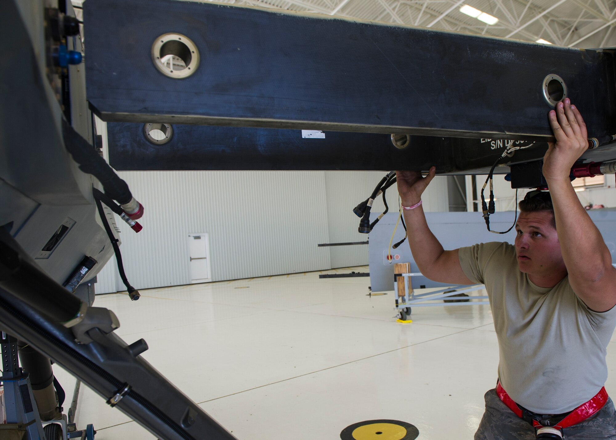 Airmen from the 49th Aircraft Maintenance Squadron affix the left wing onto an MQ-9 Reaper at Holloman Air Force Base, N.M., Oct. 13, 2015. The MQ-9 provides a unique capability to perform strike, coordination, and reconnaissance against high-value, fleeting, and time-sensitive targets. Reapers can also perform intelligence, surveillance, reconnaissance, close air support, combat search and rescue, precision strike, buddy-lase, convoy/raid overwatch, target development, and terminal air guidance. (U.S. Air Force photo by Airman 1st Class Emily A. Kenney/Released)   