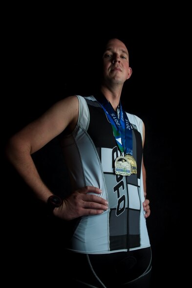 Staff Sgt. Josh Hull, NCO in charge of the Minot Air Force Base Honor Guard, poses with his Iron Man Challenge medals at Minot AFB, N.D., Oct. 13, 2015. Hull completed two Iron Man Challenges in 2015, with a best finishing time of 14 hours, 27 minutes, 31 seconds. (U.S. Air Force photo/Airman 1st Class Christian Sullivan)