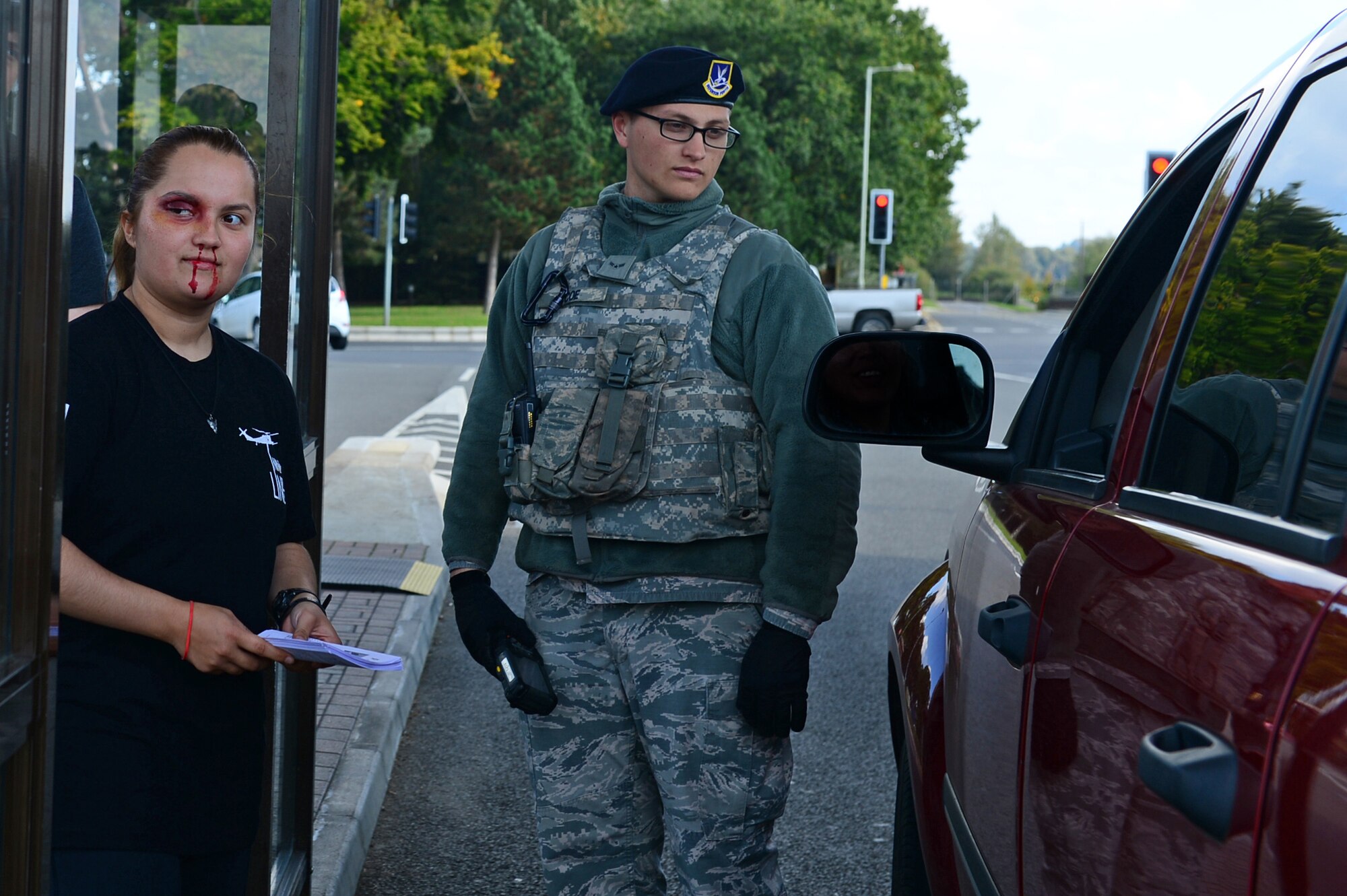 Senior Airman Miranda Kalandar, a 48th Security Forces Squadron member, distributes pamphlets promoting Domestic Violence Awareness month at Royal Air Force Lakenheath, England, Oct. 9, 2015. Victim advocate Airmen simulated black eyes to promote awareness and educate Airmen on how to assist victims of domestic violence. (U.S. Air Force photo by Senior Airman Dawn Weber/Released)
