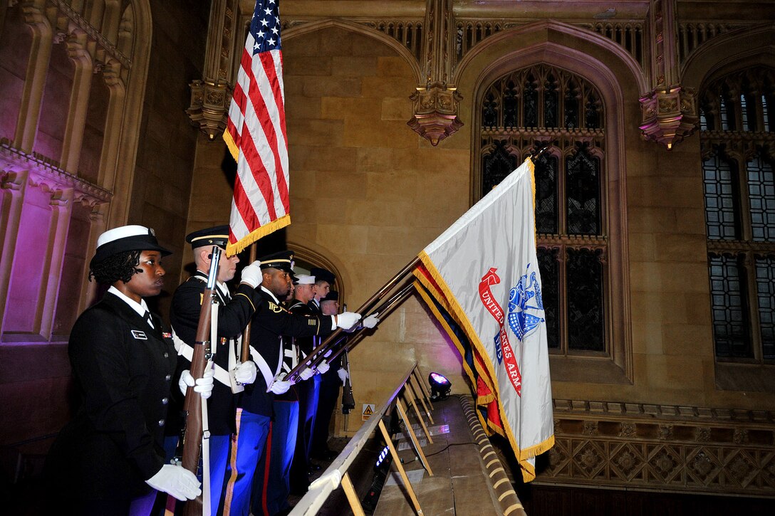 U.S. Service members assigned to the RAF Molesworth Joint Honor Guard present the colors during the Combined Joint Service Ball at King's College, Cambridge, United Kingdom Sept. 11, 2015. The only American joint honor guard team in the United Kingdom performs various ceremonies, such as retreats, retirements and funerals throughout England. (U.S. Air Force photo by Staff Sgt. Ashley Hawkins/Released)