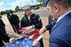 U.S. Navy Reserve Seaman Sheridan, center, U.S. Africa Command analyst and RAF Molesworth Joint Honor Guard member, assists other members with folding the American flag during a retreat ceremony at RAF Molesworth, United Kingdom, June 5, 2015. Retreat ceremonies are a part of the various events the newly-reconstructed honor guard team performs. (The last names of personnel have been romoved for security purposes) (U.S. Air Force photo by Staff Sgt. Ashley Hawkins/Released)